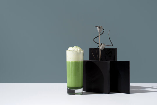 Refreshing Matcha Tea with Whipped Cream on Elegant Backdrop