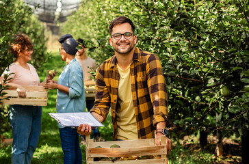 Portrait of an agriculture student in a pear orchard looking at the camera.