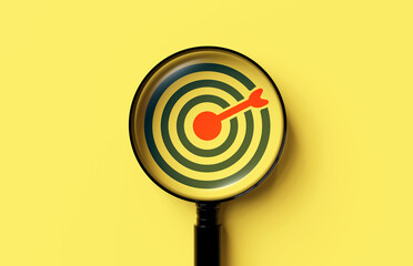 Target board icon in magnifying glass on yellow background. concept of finding goals and setting...