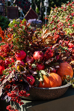 Basket of pomegranates, pumpkins, and vibrant autumn berries