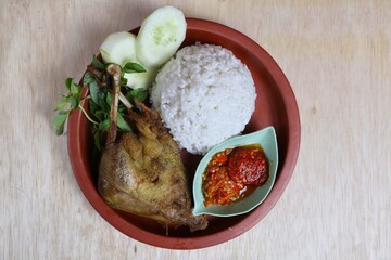 Penyet ayam or fried chicken in Indonesia is the name of a typical Javanese food consisting of fried chicken and chili sauce.