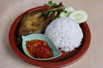 Penyet ayam or fried chicken in Indonesia is the name of a typical Javanese food consisting of fried chicken and chili sauce.