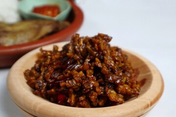 Stir-fried Tempe is a typical Indonesian dish with spices, garlic, shallots, chilies and soy sauce. served on a wooden plate
