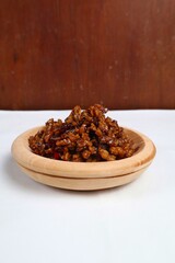 Stir-fried Tempe is a typical Indonesian dish with spices, garlic, shallots, chilies and soy sauce. served on a wooden plate