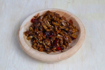 Stir-fried Tempe is a typical Indonesian dish with spices, garlic, shallots, chilies and soy sauce. served on a wooden plate