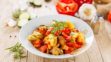 homemade French ratatouille with herbs on wooden background