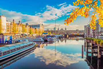 Fototapeta premium Moored boats and facades of old historic Houses over canal water, Amsterdam, Netherlands