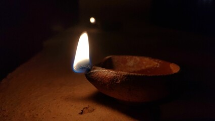 Traditional clay oil lamp with a bright flame