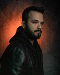 Fototapeta premium Brazilian Man in black hooded jacket with soft studio lighting highlighting the jacket's texture