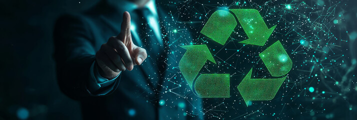 Naklejka premium A businessman's finger touches a glowing green recycle icon on a sleek, futuristic digital display