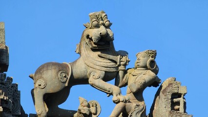 Ancient stone sculpture of a lion and human figure at historic temple.
