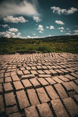 Fototapeta premium Clay bricks drying in a scenic field under a cloudy sky.