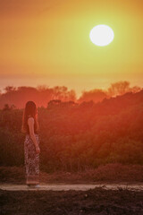 Brunette brown hair spanish model during sunset. She is thinking looking at the sun in a relaxin environment in Cadiz, Chiclana Sancti Petri area in spain