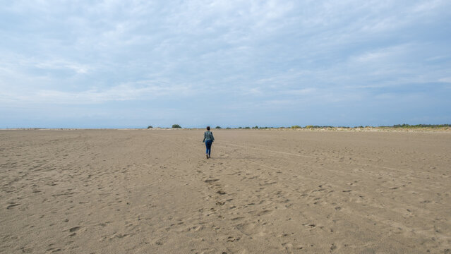 Woman walking on the Espiguette beach, south of France