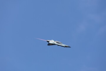 Military jet aircraft flying with afterburner flames