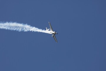 Acrobatic airplane stunt in clear blue sky