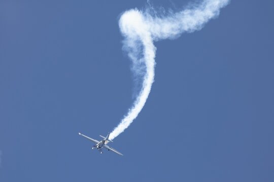 Aerobatic plane performing stunt with smoke trail