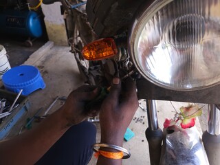 Close Up of motorbike mechanic busy repairing bike at garage. Industry concept of professional occupation, repair man and skill labor.
