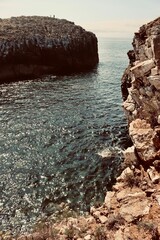 Rocky cliffs and sparkling sea under clear sky