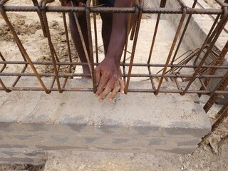 Photography, construction workers using reinforced tmt steel bar with ease at the construction site, Reinforced bar (rebar). TMT steel rods tied together forming the core of concrete