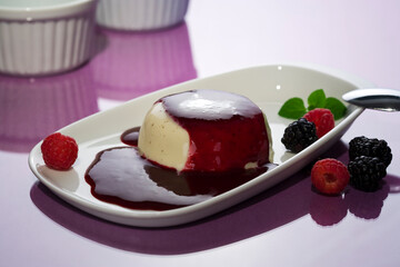 Panna Cotta, with forest berry sauce, garnished with raspberries and blackberries