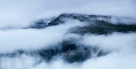 Obraz premium Serene mountain landscape shrouded in mist and fog.