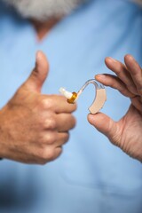 Senior man with hearing aid and thumbs up