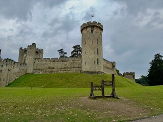 Warwick Castle with cloudy sky and green lawn