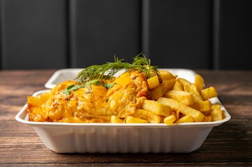 Close-up of fish and chips in a takeout container.
