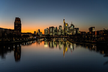 Naklejka premium A city skyline at dusk with building silhouettes against a twilight sky.