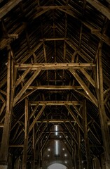 Interior of a rustic wooden barn with intricate beams
