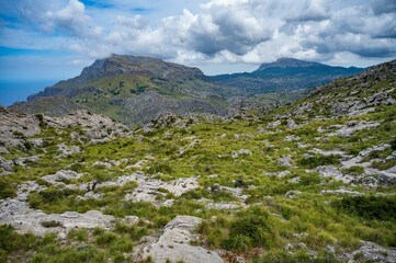 Scenic mountainous landscape with lush greenery and cloudy sky.