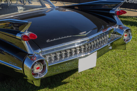 Close up of a black cadillac coupe deville showing its tail fin and bumper