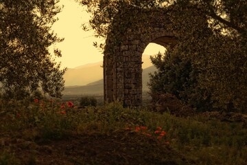 Obraz premium Ancient stone archway at sunset