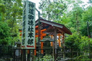 Traditional Japanese shrine surrounded by lush greenery and trees