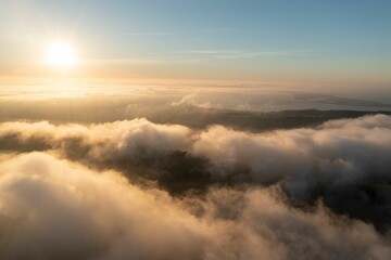 Aerial view of sunrise over mountain landscape with clouds.