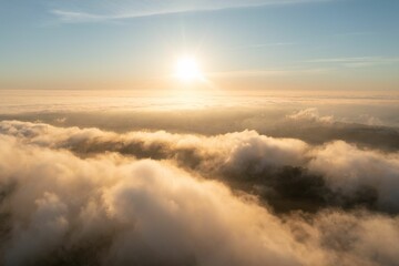 Obraz premium Aerial view of sunrise above the clouds