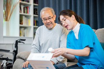 Obraz premium Asian doctor with physician visit senior male patient consult medicine dosage at house in living room, Woman nurse caregiver showing prescription drug to senior man at nursing home, healthcare support