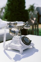 Closeup of a vintage rotary telephone on a white table in a wedding venue