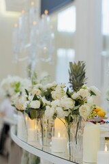 Elegant wedding table decor with white roses and candles.