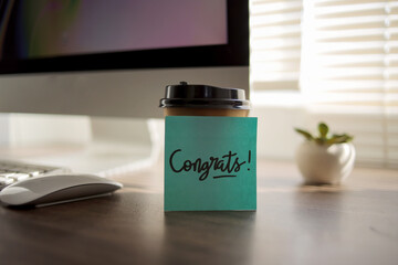 Sticky Notes with Congrats Text on Coffee Cup at Office
