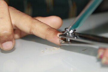 close-up of a girl trimming her nails using nail cutter.