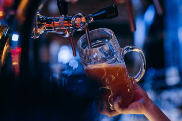 Female Bartender pouring beer at the bar. Close up hands	
