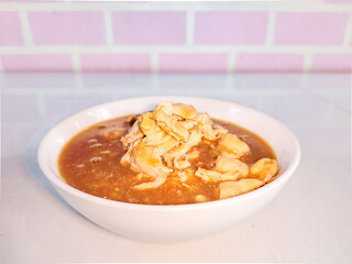 Chinese style chicken gravy sauce in a white bowl. Side view..