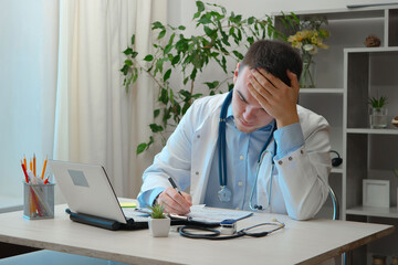 A young doctor, at his desk, receives patients.