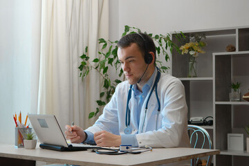 A young doctor receives patients at his workplace.