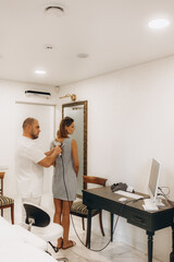 Fototapeta premium Male doctor examining mole on back of woman in clinic
