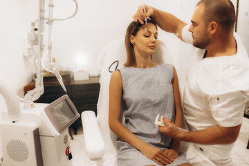 Plastic surgeon drawing dashed lines around eyes of girl, above her eyebrow. Hands in blue glove holding pencil and face. Plastic surgery, beauty portrait, closeup