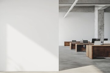 Open-plan office with blank white wall, concrete floors, and wooden desks for creative display mockups