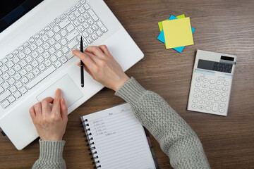 Female hands with computer in office, top view.Female hands with computer in office, top view.